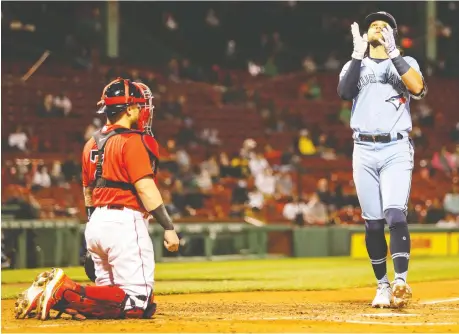  ?? ADAM GLANZMAN/GETTY IMAGES ?? ROUND TRIPPER Red Sox catcher Christian Vazquez looks on as Blue Jays shortstop Bo Bichette crosses home plate after hitting a solo home run in the fourth inning Tuesday at Fenway Park in Boston. For the game story and other MLB results, visit windsorsta­r.com