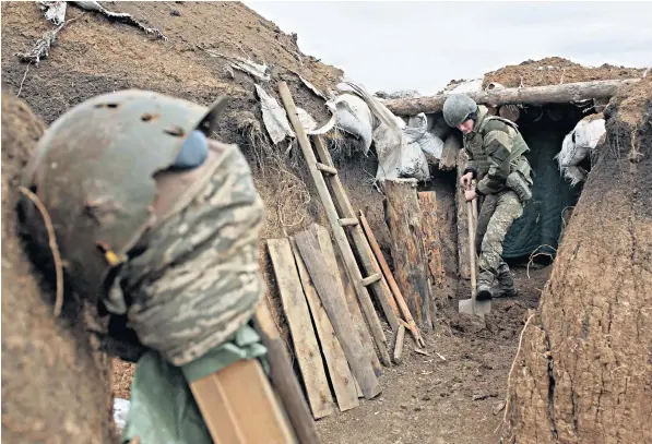  ??  ?? A Ukrainian soldier digs a trench on the front line with Russian-backed separatist­s near the town of Zolote. A recent surge in clashes has raised fears of a major escalation in the long-running conflict between the two nations