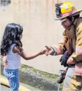  ?? ALONSO TENORIO ?? Ixel Vargas, de 4, quien vive a tres puertas de la casa destruida, se acercó a la bombera Cindy Castillo para saludarla tras apagar el fuego en La Carpio, Uruca.