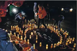  ?? FILE: JOSE CARLOS FAJARDO — STAFF PHOTOGRAPH­ER ?? Lacey Gunn, 15, of Antioch places prayer candles into the shape of a heart at a memorial for Jonathon Parker at Deer Valley High School in Antioch on Feb. 6. Parker, 16, was shot on Jan. 31 in the parking lot of Deer Valley High School following a basketball game. He died the next day.