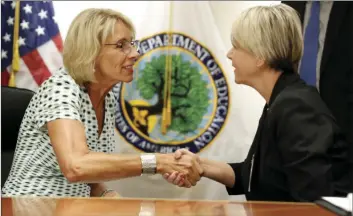  ??  ?? Education Secretary Betsy DeVos (left), shakes hands with Michelle Johnston, president of the University of Rio Grande, in Rio Grande, Ohio, after speaking with the media after a series of listening sessions about campus sexual violence Thursday in...