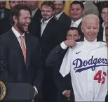  ?? JULIO CORTEZ — THE ASSOCIATED PRESS ?? Dodgers pitcher Clayton Kershaw, left, reacts as President Joe Biden holds up a baseball jersey given to him during an event at the White House to honor the 2020World Series champions in Washington on Friday. Biden is the 46th U.S. president and his jersey reflects that.