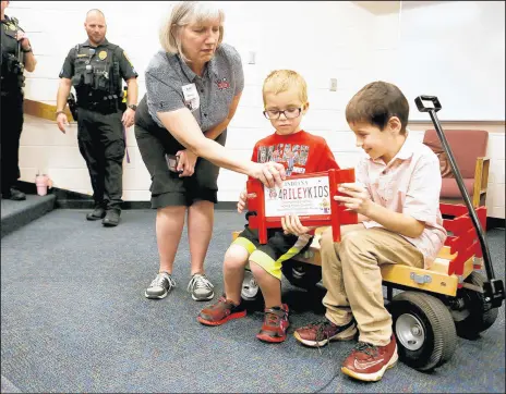  ?? SUZANNE TENNANT/POST-TRIBUNE ?? Susan C. Miles, of Riley’s Children’s Hospital gives the Riley Children’s Hospital wagon license plate to second grader Conner Pierce, left, and,Tristan Giovenco, for photos during a presentati­on at the Hobart school on Thursday.