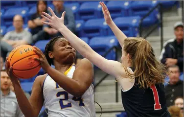  ?? at arkansason­line.com/35girls6a/
(Arkansas Democrat-Gazette/Thomas Metthe)
See more photos ?? North Little Rock’s Destine Duckworth (24) attempts a shot while defended by Rogers Heritage’s Pam Seiler on Wednesday during the first quarter of North Little Rock’s 66-21 victory in the Class 6A girls state basketball tournament at Bryant.