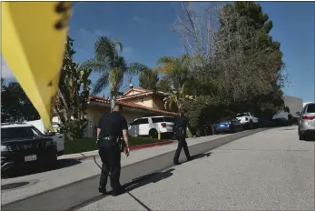  ?? RICHARD VOGEL — THE ASSOCIATED PRESS ?? Police block the street to a house Saturday where three were killed and four others wounded in a shooting in L.A.