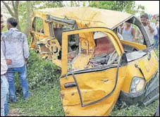  ?? PTI ?? People gather around the mangled school van after it collided with a speeding train in Kushinagar, UP, on Thursday morning.