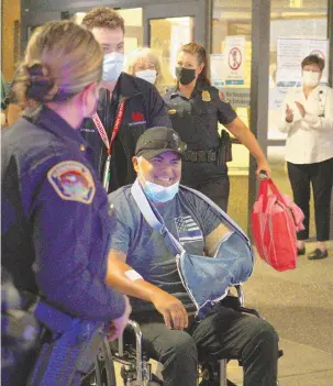  ?? ADOLPHE PIERRE-LOUIS/JOURNAL ?? Officer Mario Verbeck smiles as he is released from the University of New Mexico Hospital on Thursday, surrounded by well-wishers. He was shot in the line of duty two weeks ago.