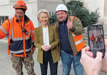  ?? ?? Ambush: The EU chief poses with two builders outside the Commission’s Europe House HQ in Westminste­r