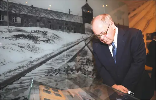  ?? (Noam Rivkin Fenton/Yad Vashem) ?? THE WRITER views the Auschwitz Album on display in the Yad Vashem Holocaust History Museum.