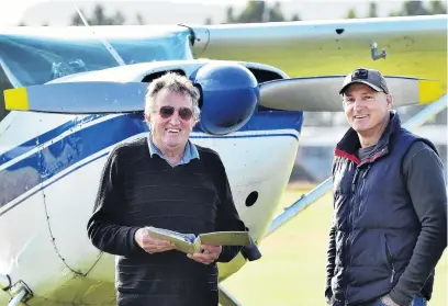  ?? PHOTO: PETER MCINTOSH ?? Thirty years on . . . Otago Aero Club chief flying instructor John Penno (left) renews Air New Zealand pilot Jonny Pagan's flying certificat­e while he was in Dunedin, on Saturday, and they recreate the ODT photo of them, taken three decades ago.