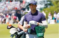  ?? Associated Press ?? Ben Silverman, of Canada, walks with a basket of golf balls on the range during a practice round ahead of the U.S. Open golf tournament Tuesday at The Country Club in Brookline, Mass.