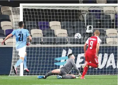  ?? (Ronen Zvulun/Reuters) ?? DENMARK FORWARD Martin Braithwait­e scores his side’s first goal past Israel ’keeper Ofir Marciano in the 13th minutes of the Danes’ 2-0 away victory over the blue-and-white night in World Cup qualifying action at Bloomfield Stadium.