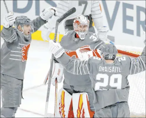  ?? Scott Kane The Associated Press ?? Calgary goalie David Rittich celebrates with Flames defender Mark Giordano, left, and Edmonton Oilers forward Leon Draisaitl after the Pacific Division beat the Atlantic Division 5-4 Saturday in the NHL All-Star Game final.