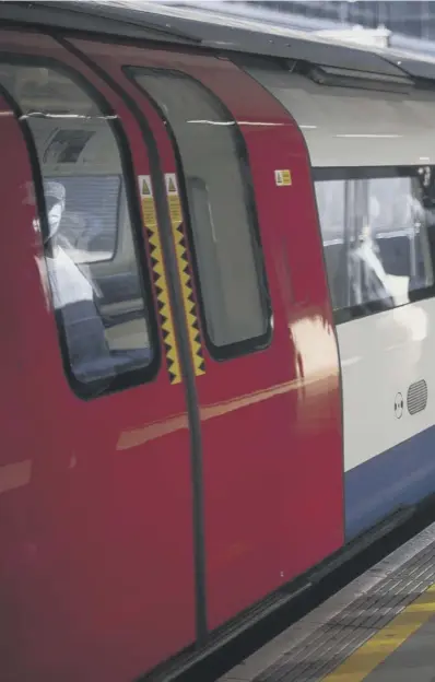  ??  ?? Passengers wear face masks and stand apart at Canning Town undergroun­d station as those using public transport in London are asked to wear face coverings to prevent those with coronaviru­s infecting others