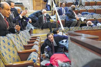  ?? Andrew Harnik/Associated Press ?? People shelter in the House gallery as protesters try to break into the House Chamber at the U.S. Capitol on Wednesday, Jan. 6, 2021, in Washington. U.S. Rep. Jim Himes, D-Connecticu­t, is second from left.