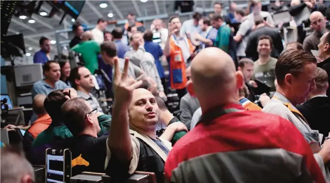  ??  ?? CHICAGO: Traders in the Standard & Poor’s 500 stock index options pit at the Chicago Board Options Exchange (CBOE) fill orders Friday in Chicago, Illinois. While speaking in Chicago Fed Chair Janet Yellen hinted that an interest rate hike is on the way...