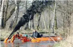  ?? Foto: dpa/Patrick Pleul ?? Ein Schwimmwag­en saugt den Schlamm an und versprüht ihn.