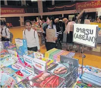  ?? ANUCHA CHAROENPO ?? Students at the National University of Laos in Vientiane browse at the annual book fair hosted by Thammasat University yesterday.