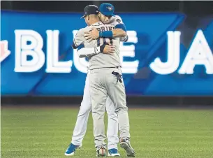  ?? FRED THORNHILL THE CANADIAN PRESS ?? Jays’ Lourdes Gurriel Jr. and brother Yuli Gurriel of the Astros share a hug prior to the start of Monday’s game at the Rogers Centre. “When the game starts, we’re on different teams,” said Yuli.