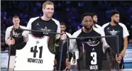  ?? CHUCK BURTON ?? Dirk Nowitzki, of the Dallas Mavericks and Dwyane Wade, of the Miami Heat, are given jerseys during the second half of the NBA All-star basketball game, Sunday, Feb. 17 in Charlotte, N.C.