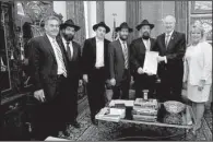  ?? Special to the Democrat-Gazette/RANDALL LEE ?? State Rep. Charlie Collins (from left), Rabbi Benzion Pape, Mendel Ciment, Rabbi Yosef Kramer, Rabbi Pinchus Ciment, Gov. Asa Hutchinson and state Rep. Robin Lundstrum hold the newly-signed proclamati­on designatin­g April 7 a statewide Education and...