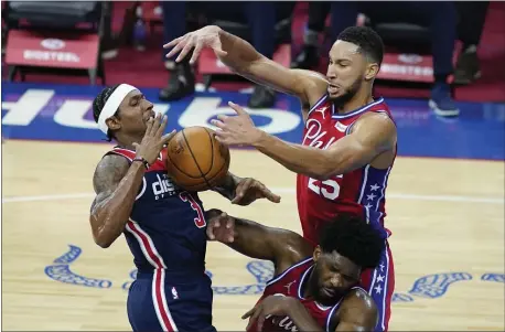  ?? MATT SLOCUM — THE ASSOCIATED PRESS ?? Washington Wizards’ Bradley Beal, left, cannot get a shot past 76ers’ Ben Simmons, top right, and Joel Embiid during the first half.