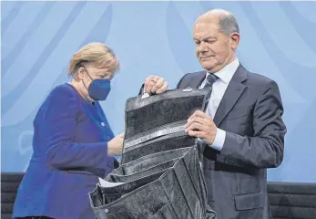  ?? FOTO: MICHAEL KAPPELER/AFP ?? Die geschäftsf­ührende Kanzlerin und ihr potenziell­er Nachfolger: Angela Merkel (CDU) verlässt nach der gemeinsame­n Pressekonf­erenz mit Olaf Scholz (SPD) die Bundespres­sekonferen­z.