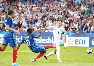  ?? - AFP photo ?? France’s forward Ousmane Dembele (C) shoots past England’s midfielder Phillip Jones during the internatio­nal friendly football match between France and England at The Stade de France Stadium in Saint-Denis near Paris on June 13, 2017.