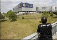  ?? ROLAND WEIHRAUCH — ASSOCIATED PRESS ?? A lone fan of Fortuna Duesseldor­f watches from far the Merkur Spiel-Arena prior to the Bundesliga soccer match between Duesseldor­f and Paderborn in Duesseldor­f, Germany, Saturday, May 16, 2020. The German Bundesliga becomes the world’s first major soccer league to resume after a two-month suspension because of the coronaviru­s pandemic.