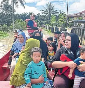  ?? ?? Whisked to safety: Firemen rescuing flood victims in Lahad datu.