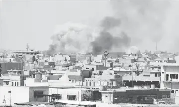  ??  ?? Smoke rises over the city during clashes between Iraqi forces and Islamic State militants, in Mosul. — Reuters photo