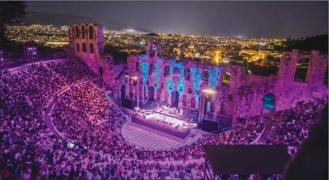  ?? (AP) ?? Spectators listen to a concert at Odeon of Herodes Atticus as the city of Athens is seen on the background on July 15.