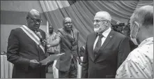  ?? AFP ?? The President of the Central African National Assembly, Simplice Mathieu Sarandji (left), gives a letter of congratula­tions to the representa­tive of Russian instructor­s in Bangui on Friday for their “great efficiency” in rebel-held areas, just before a truce was announced.