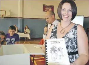  ?? ELIZABETH PATTERSON/CAPE BRETON POST ?? Cara Martin shows a St. Agnes Elementary School cookbook that was one of many items discovered in the St. Agnes Elementary School time capsule just after it was opened Saturday afternoon as part of the school’s 100th anniversar­y celebratio­ns. Martin...