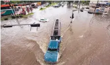  ?? GODOFREDO A. VASQUEZ/HOUSTON CHRONICL ?? A motorist drives through floodwater­s on West Mount Houston Road near Interstate 45 North on Tuesday in Houston. Emergency officials urge motorists to stay home until the water recedes.