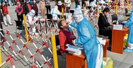  ?? — AFP ?? On the front lines: A health worker taking a swab sample from a resident during a Covid-19 screening in Qingdao, Shandong province.