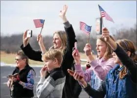  ?? MARIAN DENNIS – DIGITAL FIRST MEDIA ?? Family members of Chad Carvalho, 34, an army maintenanc­e test pilot, wave American flags and eagerly await his landing as he flies a Black Hawk helicopter into Heritage Field Airport in Limerick.