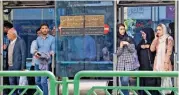  ?? (AFP) ?? People gather at a bus stop in Tehran on Saturday