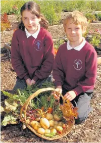  ??  ?? ●●Bethany Wild (10) and Rhys Spencer-Reeves(8) with part of Alice Ingham RC Primary School’s harvest crop