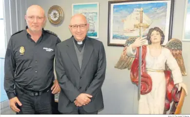  ?? POLICÍA NACIONAL ?? El comisario de La Isla, Rafael Borque, junto al párroco Gonzalo Núñez, y la imagen del Santo Ángel Custodio.