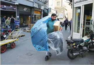  ??  ?? A man carries car parts at a market in downtown Tehran. Anger and frustratio­n over the economy has been the main fuel for the surprise eruption of protests that began on Dec. 28, 2017. (AP)