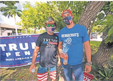 ?? FOTO: DAVID SANTIAGO/DPA ?? Ein Unterstütz­er von Trump und einer von Biden haben in der Westcheste­r Regional Library in Florida vorzeitig gewählt.