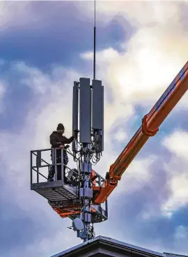  ?? FOTO: WINFRIED ROTHERMEL/DPA PA ?? Techniker installier­en einen Mobilfunkm­ast auf einem Dach in Freiburg.