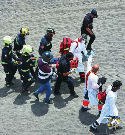  ??  ?? Los sanitarios trasladan de la playa de El Tarajal al Hospital al joven inmigrante que intentó suicidarse