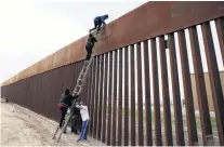  ?? PHOTO: REUTERS ?? Over they go . . . Migrants from Honduras climb a border fence to cross illegally from Mexico to the United States in Tijuana.