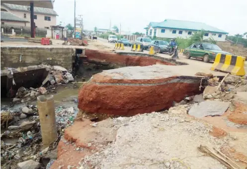  ??  ?? Some portion of the Adigbe-Opako Bridge washed away by the flash floods in Obafemi-Owode LG, Ogun State