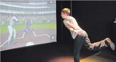  ?? LAURA BARTON THE WELLAND TRIBUNE ?? Samuel Thompson follows through after throwing a baseball while testing out a simulator at AllSports Simulated in Welland.