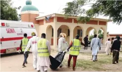  ??  ?? MAIDUGURI: Rescue workers remove a body following a suicide attack at a camp of people displaced by Islamist extremists.