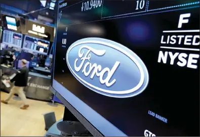  ?? AP/RICHARD DREW ?? The logo for the Ford Motor Co. appears above a post on the floor of the New York Stock Exchange on Tuesday. Ford is moving ahead with plans to cut 10 percent of its salaried workforce.