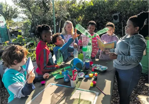 ?? Six young children gather around a craft table, with a model of the Earth, while listening to their teacher. Excellent teachers are creative, engaged and engaging, and acknowledg­e what worked and what did not. Photo: Alistair Berg/Getty Images ??